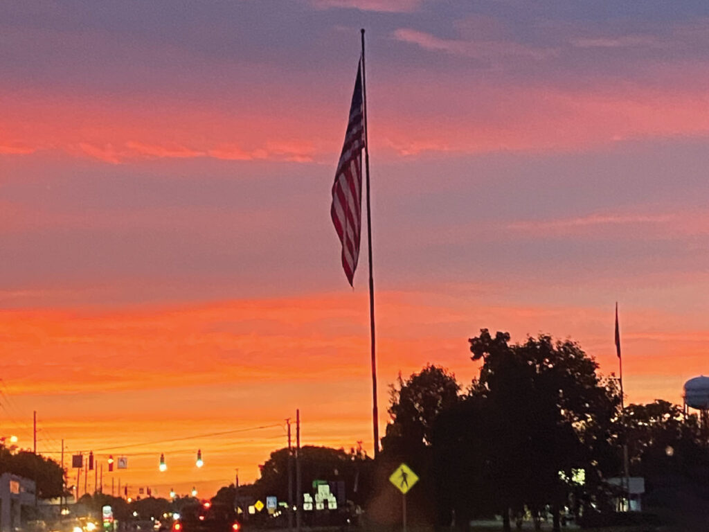 American flag at sunset in the city