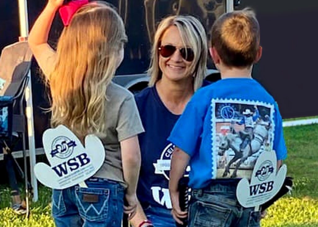 WSB employee smiling with children at a rodeo.